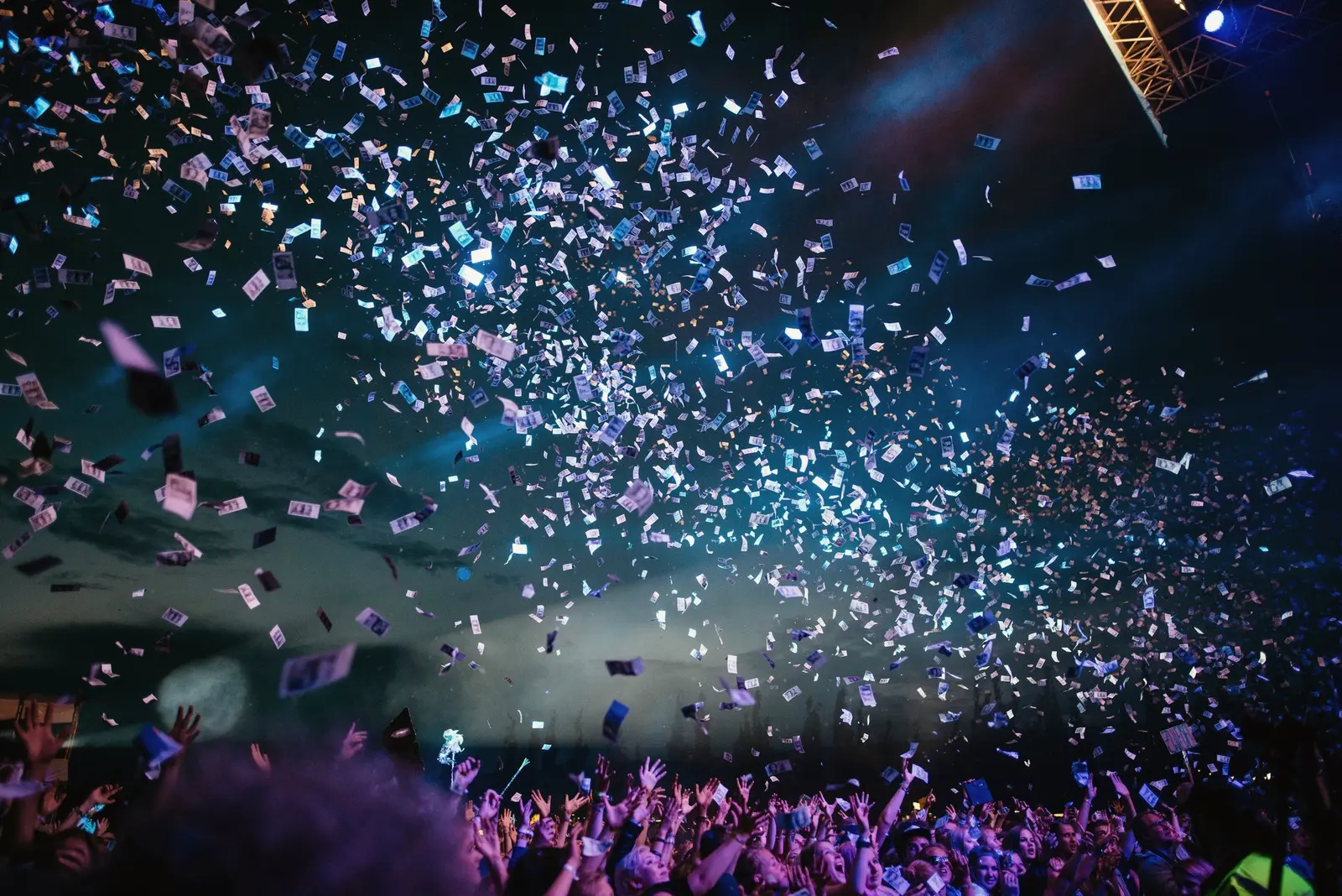 Confetti falling over a crowd under coloured lights