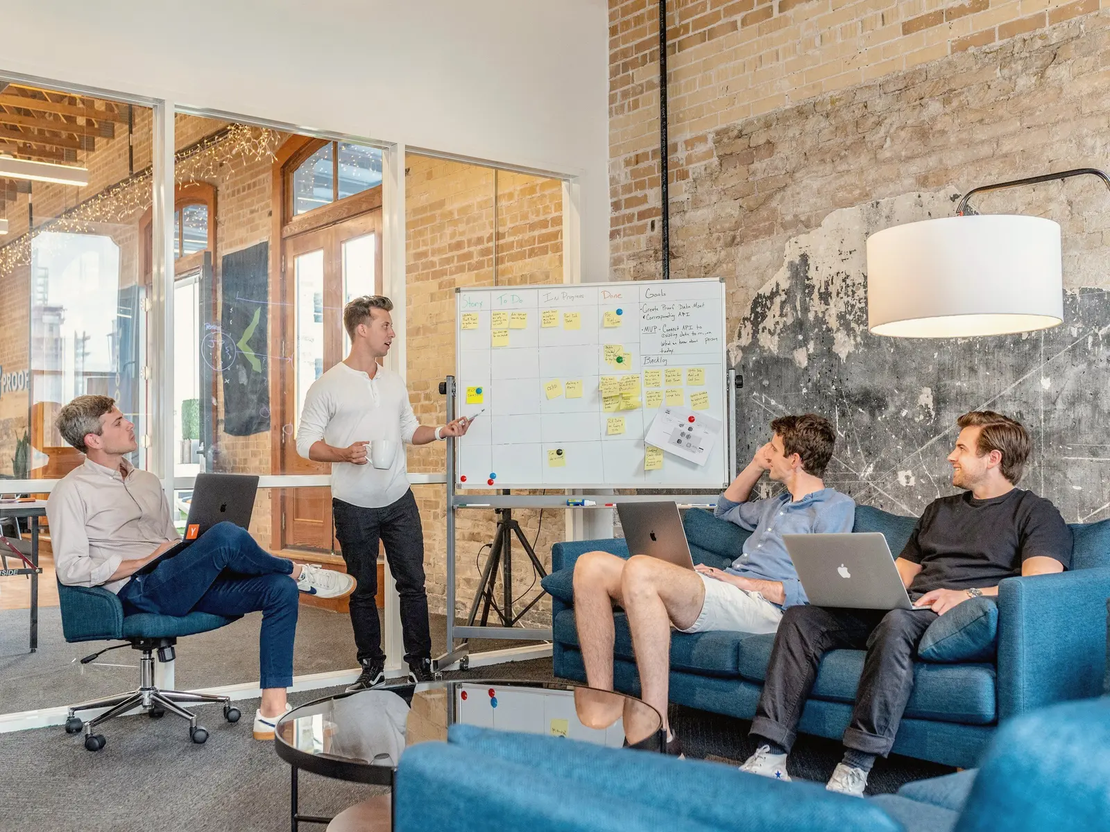 Team member presenting to colleagues seated on sofas