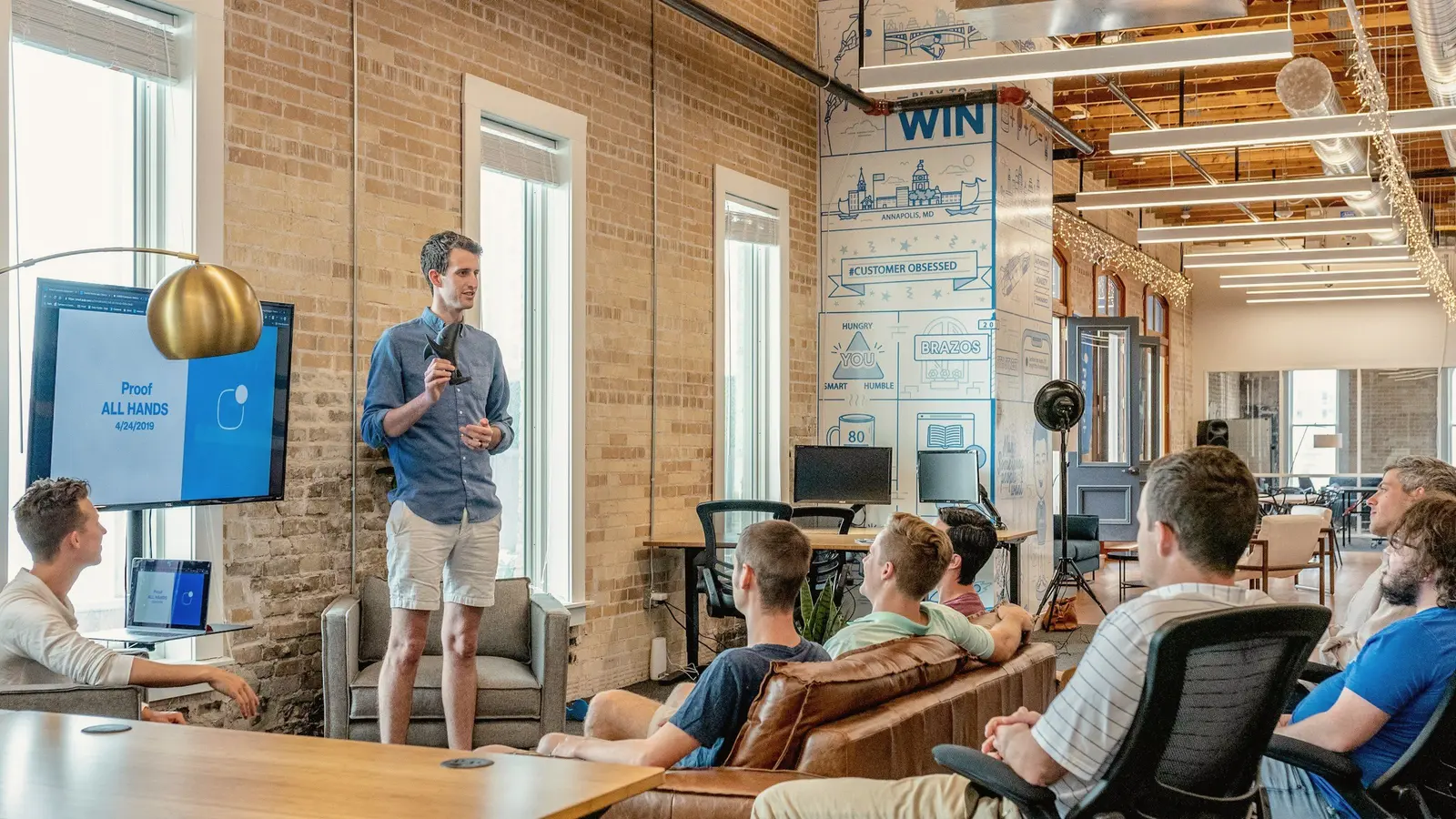 Speaker addressing a small group in an open office