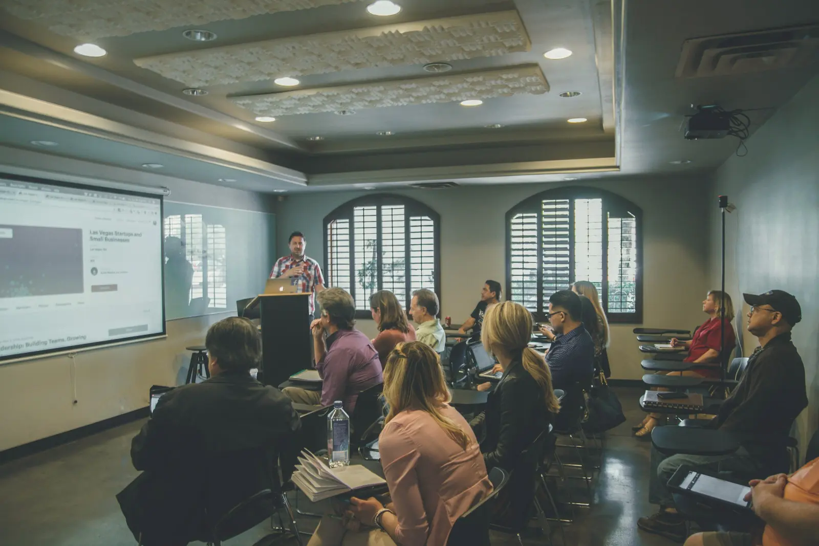 Seminar participants seated in rows facing a screen