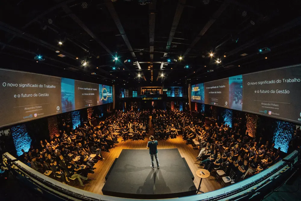 Keynote speaker on a lit stage before a full hall